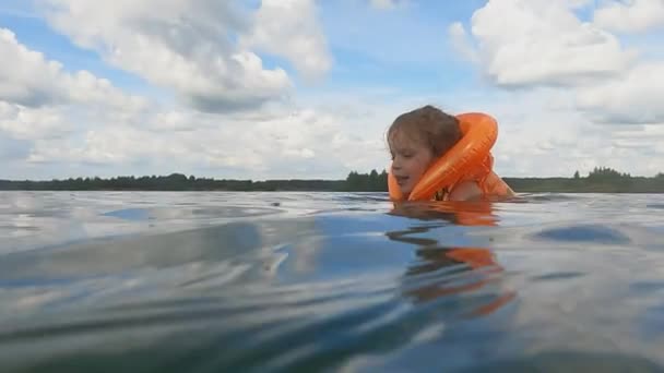 Het meisje zwemt in het water op een zonnige warme dag — Stockvideo