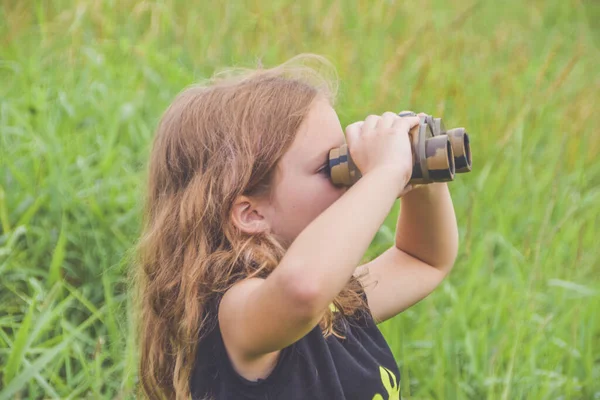 Dívenka Stojí Louce Dívá Dalekohledem — Stock fotografie