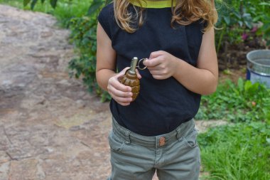 Çocuk, fotoğrafın dışında bir el bombası buldu.