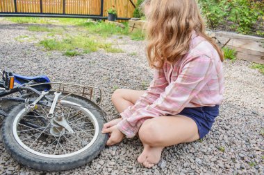 Bir kız çocuğu bisiklet tekerleğine zarar verdi ve işlemden geçmeden fotoğraf onarıyor.