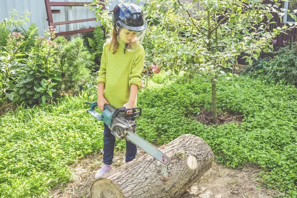 Seorang Anak Perempuan Memakai Helm Dengan Gergaji Listrik Menggergaji Kayu — Stok Foto