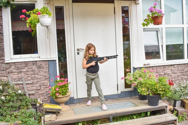Menina Criança Com Rifle Guarda Sua Própria Foto Casa Sem Fotos De Bancos De Imagens