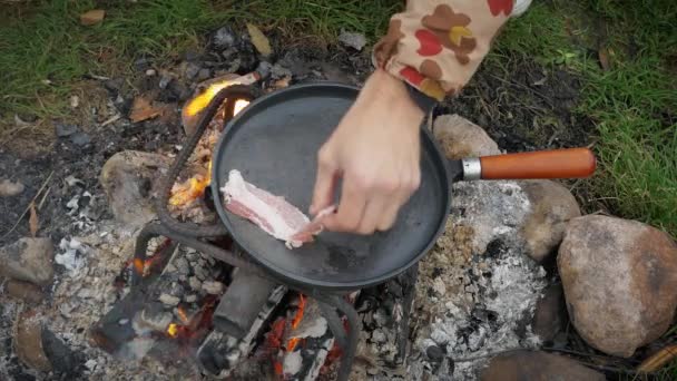 Man Friet Spek Eieren Met Specerijen Een Koekenpan Bij Rivier — Stockvideo