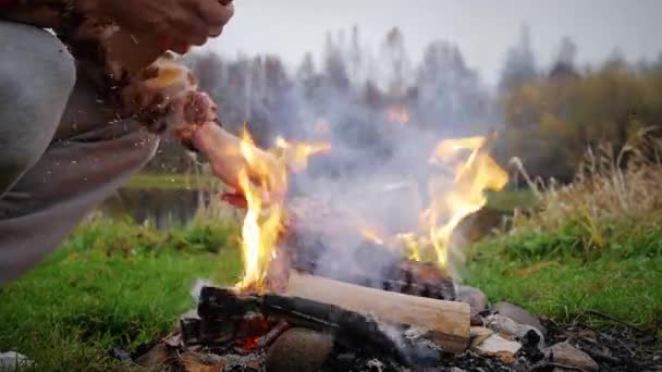 Τύπος Πετάει Καυσόξυλα Στη Φωτιά Δίπλα Στο Ποτάμι Φθινόπωρο — Αρχείο Βίντεο