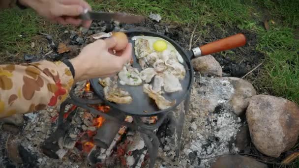 Man Friet Spek Eieren Met Specerijen Een Koekenpan Bij Rivier — Stockvideo