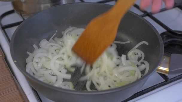 把洋葱放在油锅里煎 用木铲搅拌 — 图库视频影像