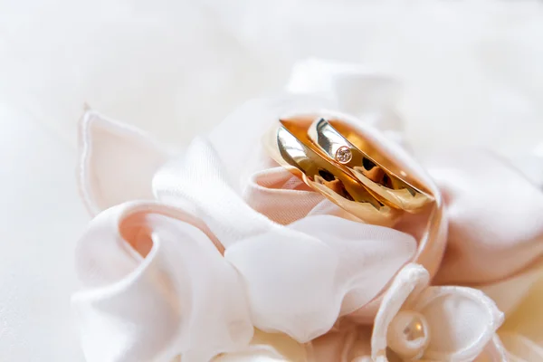 Golden wedding rings with diamond on silk fabric. Wedding jewelry details. — Stock Photo, Image