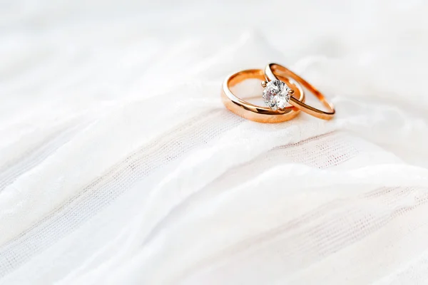 Anillos de boda de oro con diamante mentira entela blanca. Símbolo de amor y matrimonio . — Foto de Stock