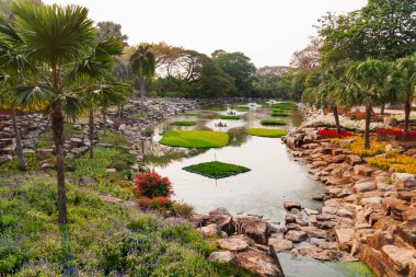 Nong Nooch Tropical Garden Pattaya, Tayland. Palmiye ağaçları ile güzel gölet.