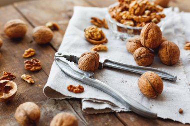 Rustik saf peçete üzerinde ceviz ile cam kase. Eski ahşap arka plan üzerinde sağlıklı snack.