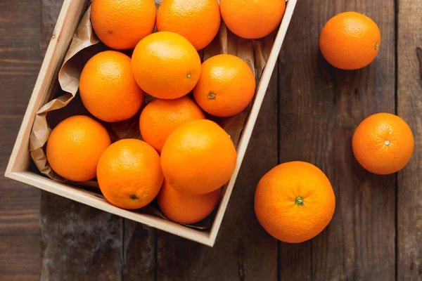 Caixa cheia de laranjas frescas. Colheita de frutas no velho fundo de madeira rústica . — Fotografia de Stock