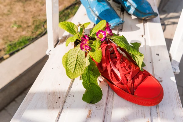 Decoraciones callejeras divertidas - botas viejas pintadas con plantas y flores en el interior . — Foto de Stock