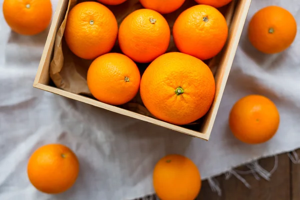Caixa cheia de laranjas frescas. Colheita de frutas em mesa de madeira rústica . — Fotografia de Stock
