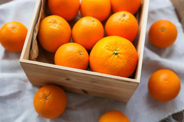 Caixa cheia de laranjas frescas. Colheita de frutas em mesa de madeira rústica . — Fotografia de Stock