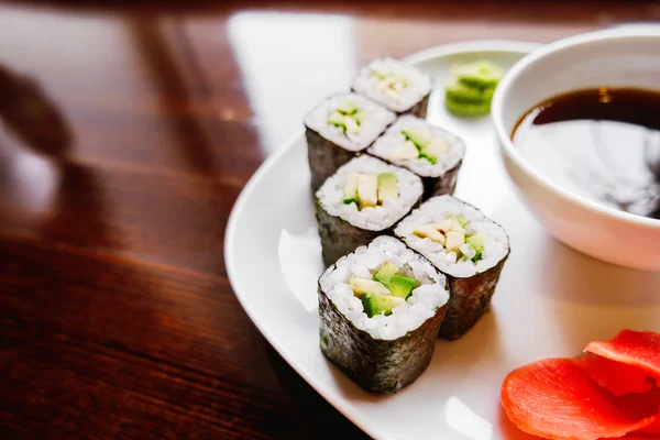 Rollos en algas nori con aguacate, jengibre en escabeche y salsa de soja. Cocina asiática, plato tradicional - sushi . — Foto de Stock