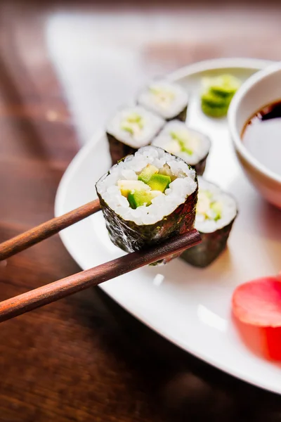 Rollos en algas nori con aguacate, jengibre en escabeche y salsa de soja. Cocina asiática, plato tradicional - sush — Foto de Stock