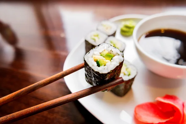 Rollos en algas nori con aguacate, jengibre en escabeche y salsa de soja. Cocina asiática, plato tradicional - sush — Foto de Stock