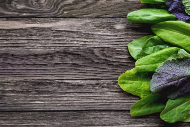 Ahşap arka plan üzerinde kuzukulağı ve salata taze yaprakları. 