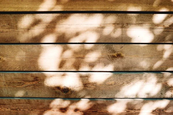 Houten achtergrond van oude hek met roestige spijkers. Shabby textuur van houten planken met zonlicht vlekken. — Stockfoto