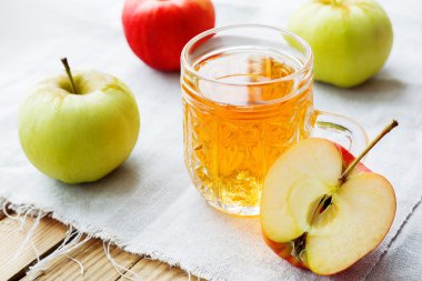 Elma ve elma suyu cam saf peçete üzerinde rustik arka plan.