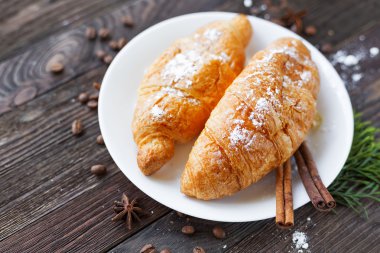 Continental Kahvaltı arka plan - kruvasan tarçın ile çifti. Rustik ahşap arka plan.