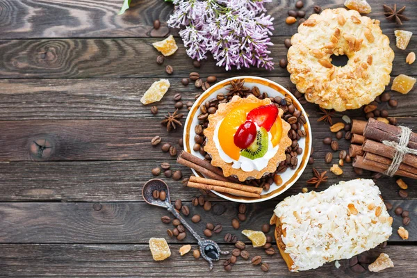 Rustieke houten achtergrond met verschillende gebakjes - taarten van pinda en vruchten, marsepein broodje. — Stockfoto