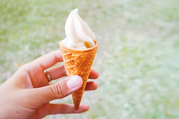 La mujer sostiene un cono de helado. Postre cremoso congelado en cono de gofre. Lugar para el texto . — Foto de Stock
