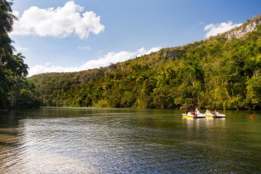 Katamaran float turistlere ormanlık dağlar arasında nehir aşağı. Küba.