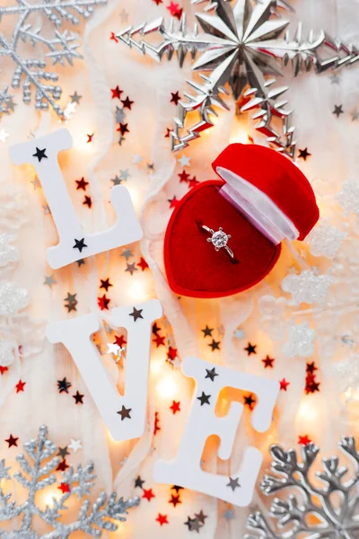 Fondo de Navidad, Año Nuevo y San Valentín con anillo de compromiso, bombillas y decoraciones. Símbolo de amor y matrimonio . — Foto de Stock