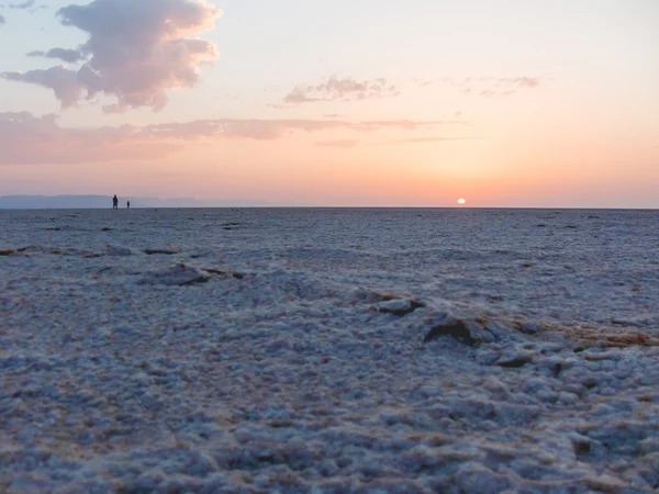 Salida del sol en el desierto del Sahara. Dos hombres saludaron al amanecer en Salt Lake. Túnez . — Foto de Stock