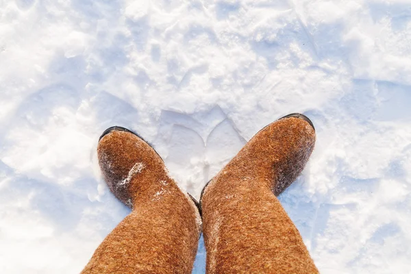 Russische traditionele winter schoeisel - Valenok. Zonnige winterdag, bovenaanzicht op voeten Gevilte wol laarzen. — Stockfoto