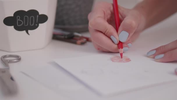 La donna con smalto azzurro su unghie disegna la zucca. Decorazioni fatte a mano per Halloween. Adesivi fai da te su per vasi di fiori. — Video Stock