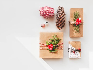 Noel hediyeleri, köknar ağacı dalları ve kırmızı kalplerle el sanatları kağıdına sarılı. Yeni yıl hediyelerinde en iyi manzara. Şenlik arka planı. Kış tatili ruhu. Kopyalama alanı olan pankart.