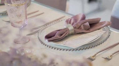 Sofra ziyafet için çatal bıçak, şarap bardağı ve peçeteyle servis edildi. Pastel renkli dekorasyonlar.