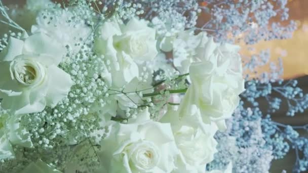 Vita rosor och blå zigenare i en vas på ett bord dekorerat för en fest. Naturlig dekoration. — Stockvideo