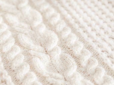 El yapımı kablo örülü kazak. Kalıplı, sıcak örülmüş kumaş dokusu. Beyaz hırka. Kucaklaşma havası için rahat sonbahar kıyafeti.