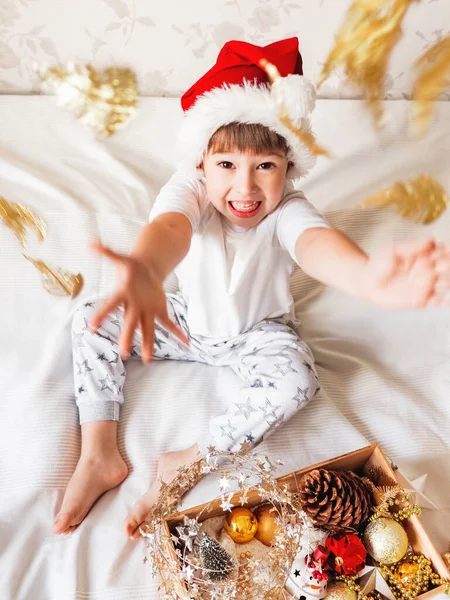 Radosny Chłopiec Kapeluszu Świętego Mikołaja Bawi Się Dekoracjami Choinki Zabawny — Zdjęcie stockowe