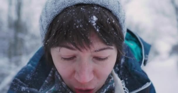Kvinna värmer sina kalla händer med andedräkt Kul i snöig vinterskog. Kvinnan skrattar när hon går genom skogen. Allvarliga känslor. — Stockvideo