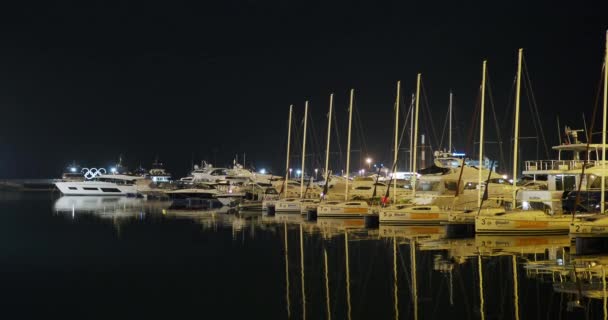 SOCHI, RUSSIA - March 03, 2020. Yachts moored at pier. Famous building of Sochi seaport at night. — Stock Video