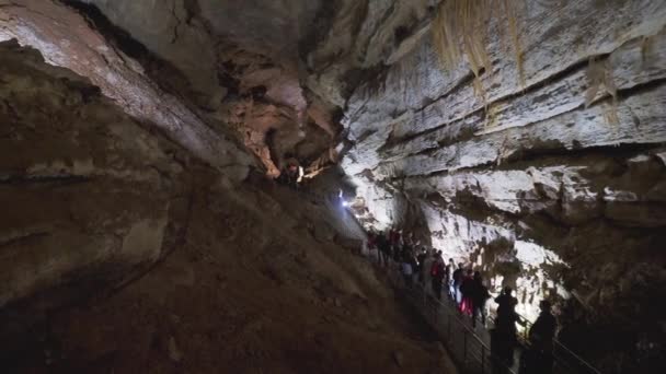 NUEVOS ATHOS, ABKHAZIA - 09 de marzo de 2020. Los turistas caminan en la cueva de New Athos. Novoafonskaya, Novy Afon o Nueva Cueva Afon. — Vídeo de stock