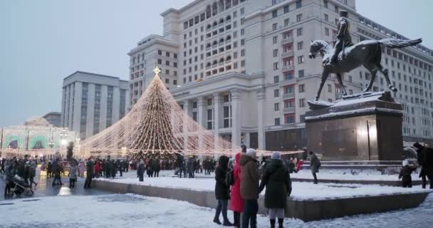 Μόσχα, Ρωσία - 08 Ιανουαρίου, 2021. Οι άνθρωποι περπατούν γύρω διακοσμημένο χριστουγεννιάτικο δέντρο μπροστά από το ξενοδοχείο Four Seasons στην πλατεία Manezhnaya. — Αρχείο Βίντεο
