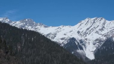 Abhazya 'daki Ritsa Gölü üzerindeki dağların panoramik manzarası. Dağ yamaçları arasındaki ünlü simge..