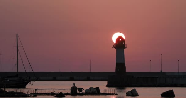 Sylwetka latarni morskiej na pięknym tle zachodu słońca. Port Soczi, Rosja. — Wideo stockowe