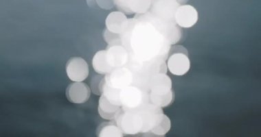 Bulanık güneş ışınları deniz yüzeyinde parlıyor. Odaklanamayan parlak güneş yansıması.