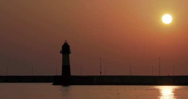 Silhouette des Leuchtturms vor herrlichem Sonnenuntergang. Hafen von Sotschi, Russland. — Stockvideo