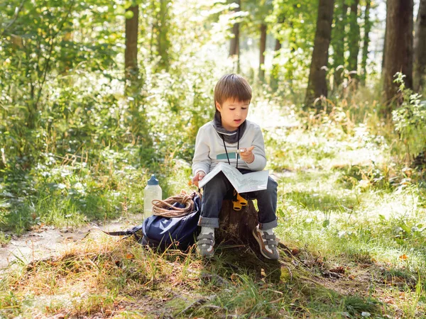 Маленький Исследователь Походе Лесу Мальчик Биноклем Компасом Сидит Пне Читает — стоковое фото
