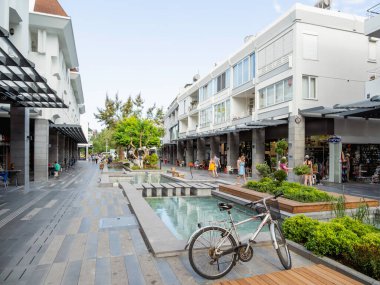 KEMER, TURKEY - 13 Mayıs 2018. Turistler Munir Özkul Liman caddesinde yürüyor. Modern binalar, dükkanlar ve çiçek yataklarıyla dolu bir sokak..