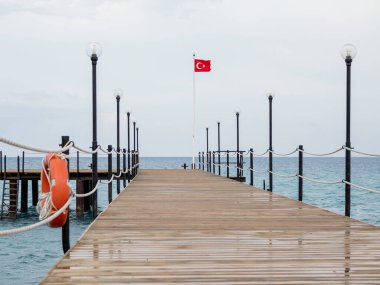 Turuncu can simidi ve Türkiye bayrağıyla terk edilmiş duba. Coronavirus COVID19 karantina ve seyahat tabusu yüzünden boş otel ve pansiyonlar. Turizme uygulanan yasağın sonuçları. Kemer, Türkiye.