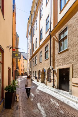 STOCKHOLM, İSVEÇ - 6 Temmuz 2017. Stockholm 'ün tarihi bölümünde parlak güneş dar sokaklara yansıyor. Gamla Stan 'deki eski moda bina, şehrin eski bir kısmı..