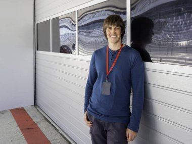 Kırmızı kurdeleli, geniş gülümseyen adam Autodrom 'da pit lane' de kalıyor. Spor araba yarışı. Özel pistte spor müsabakası.